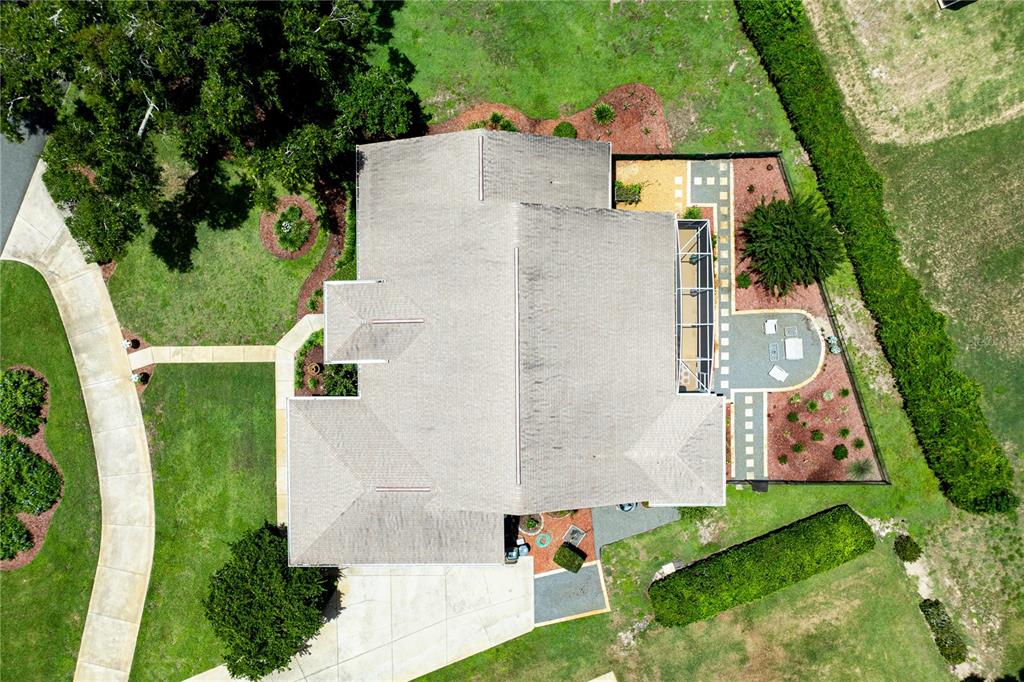 An aerial view of a suburban house with a screened-in patio and fenced backyard — 34021 PARK LANE, LEESBURG, FL