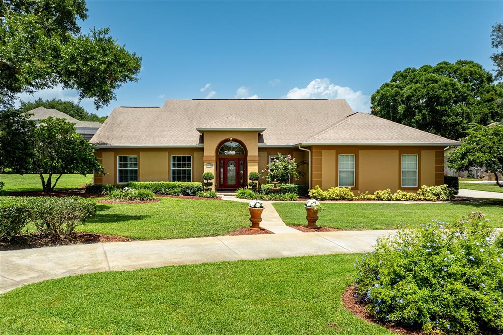 An aerial view shows a house with a shingled roof, patio, and landscaped yard — 34021 PARK LANE, LEESBURG, FL