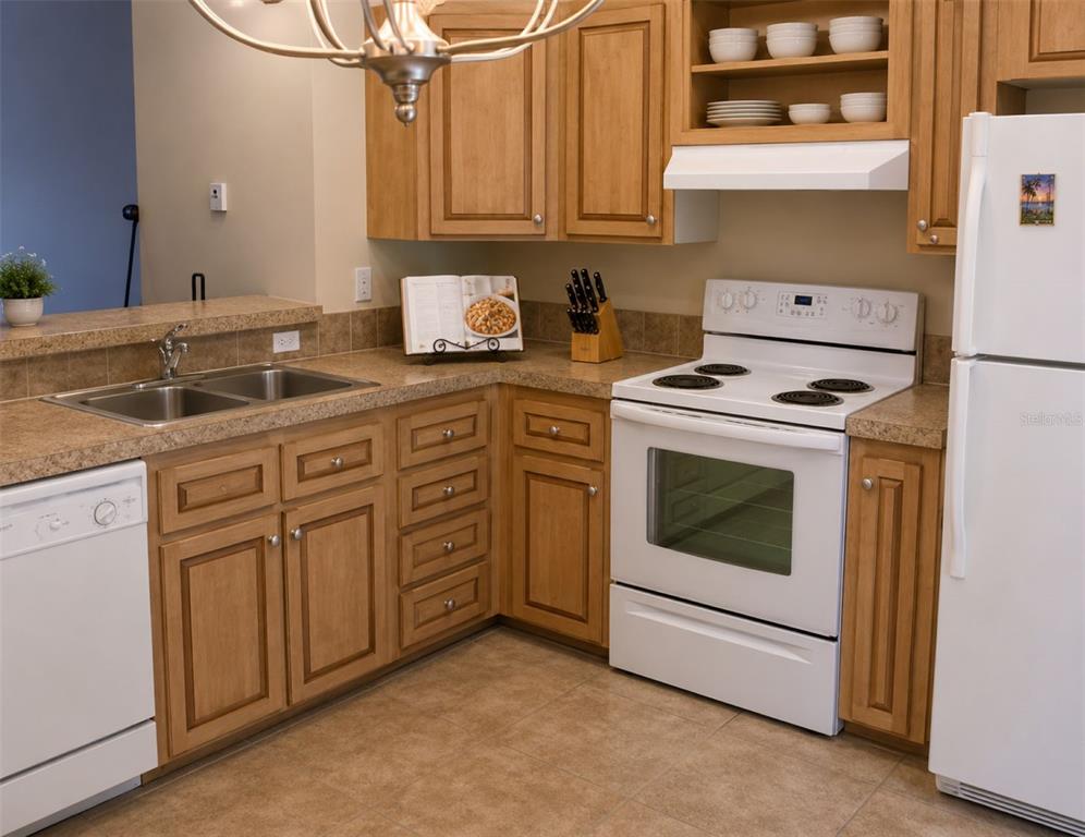 A kitchen features light wood cabinets, white appliances, and a tan countertop — 791 35TH AVENUE S, ST PETERSBURG, FL