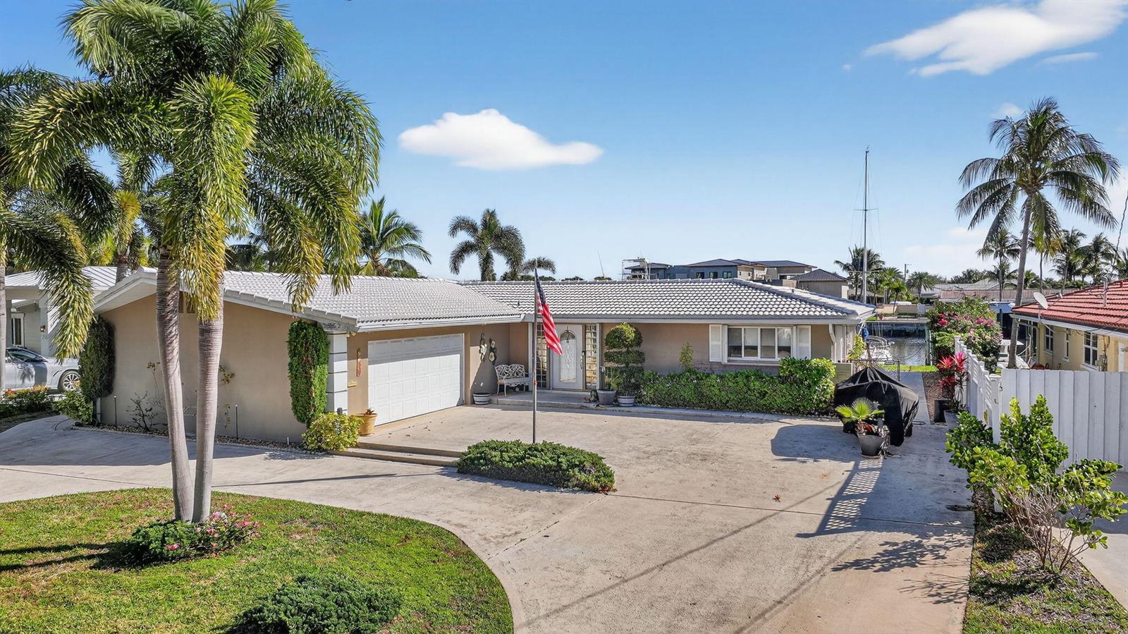 A single-story house with a white tile roof, a two-car garage, and palm trees — 752 Lagoon Drive, North Palm Beach FL 33408, NORTH PALM BEACH, FL