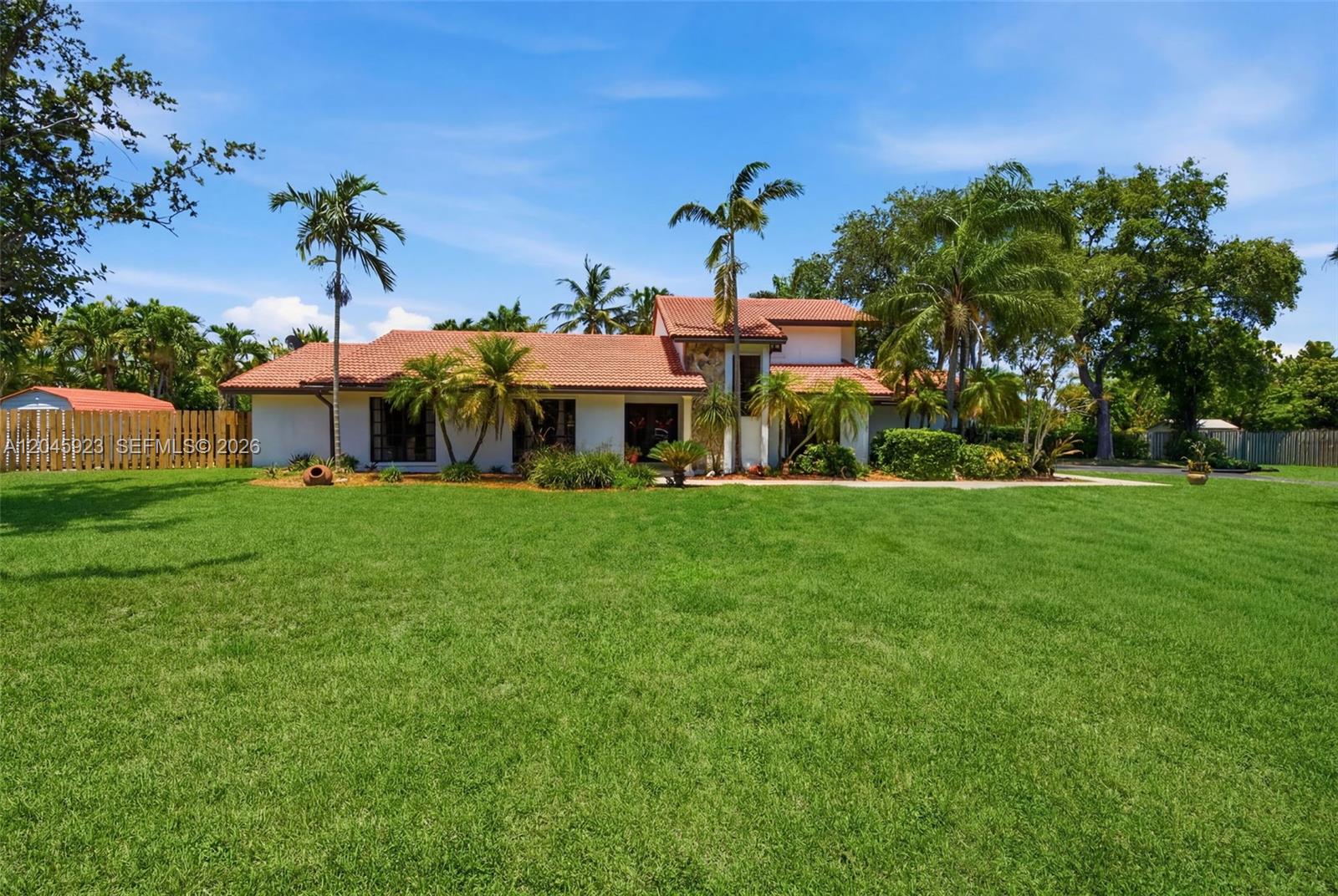 A single-story house with a red tile roof sits behind a large green lawn — 16564 SW 153rd Ct, Miami FL 33187, MIAMI, FL