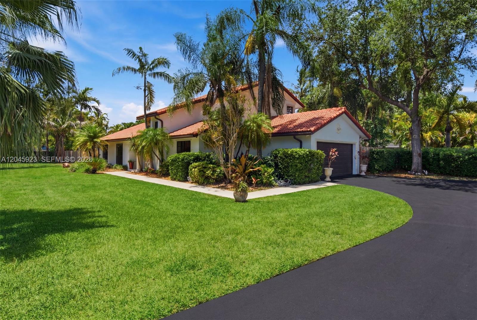 A two-story house with a red tile roof, white stucco walls, and a paved driveway — 16564 SW 153rd Ct, Miami FL 33187, MIAMI, FL