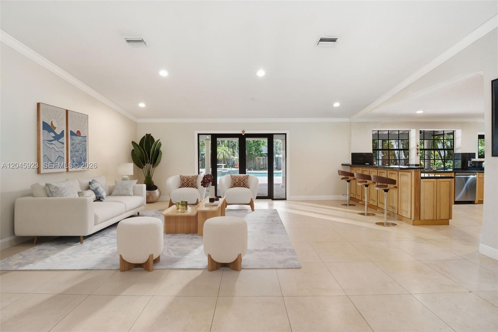 A bright living room features a white sofa, two armchairs, and an adjacent kitchen bar — 16564 SW 153rd Ct, Miami FL 33187, MIAMI, FL