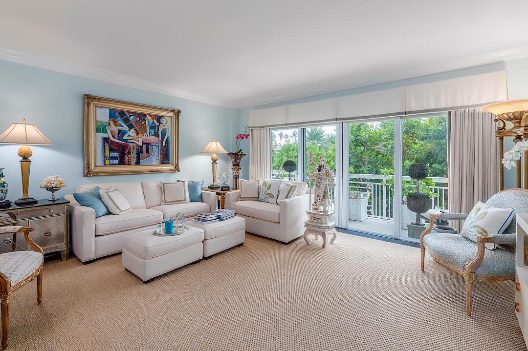 A living room features light blue walls, white sofas, a patterned armchair, and a balcony — 250 Bradley Place # 202, Palm Beach FL 33480, PALM BEACH, FL