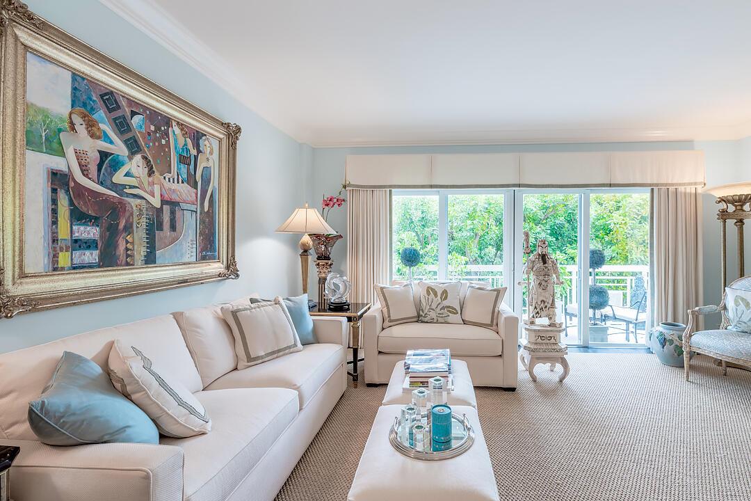 A living room features a large painting, a white sofa, and sliding glass doors to a balcony — 250 Bradley Place # 202, Palm Beach FL 33480, PALM BEACH, FL