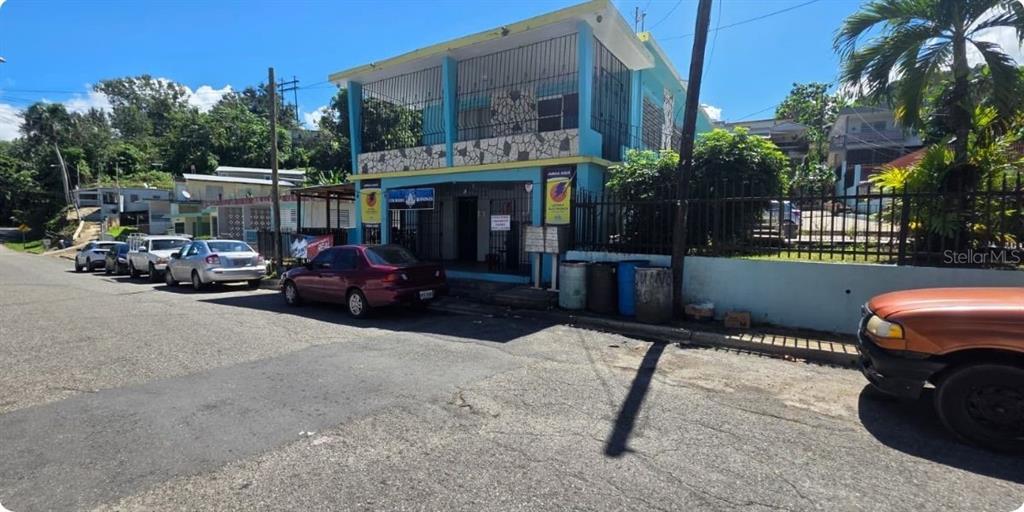 A two-story blue building with a stone-accented facade sits along a paved street — Carr PR-123 Km 78.9 BO HATO VIEJO, ARECIBO, PR