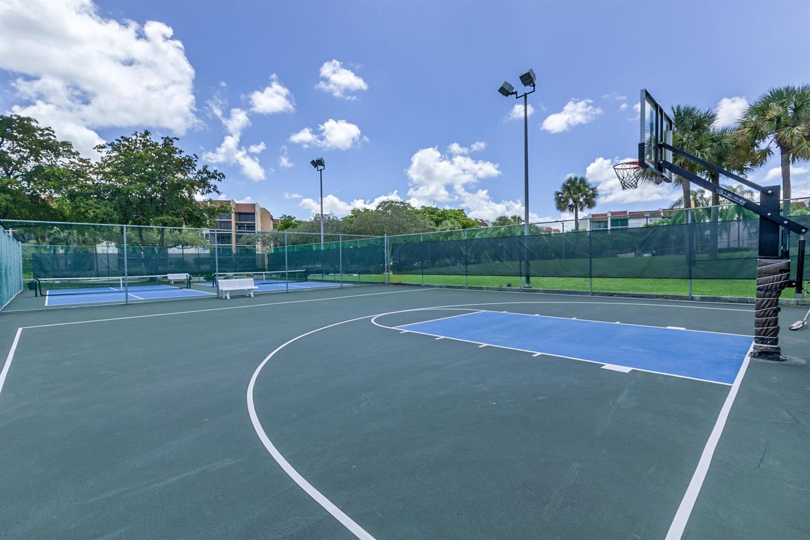 An outdoor basketball court with a blue key and surrounding chain-link fencing — 3671 Environ Boulevard # 169, Lauderhill FL 33319, LAUDERHILL, FL