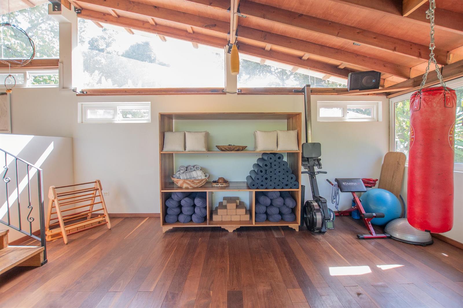 A home gym with wooden floors, a shelving unit, exercise equipment, and a punching bag — 21 Hummingbird Way, 00000, FL