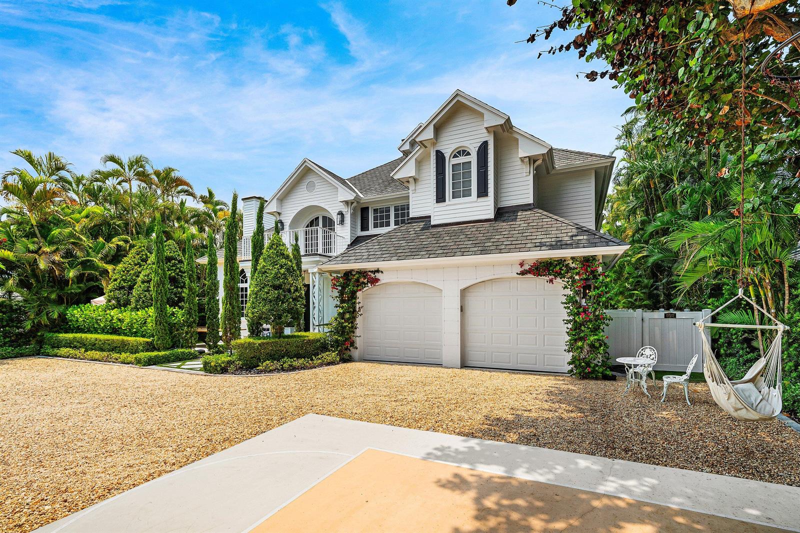 A two-story house with a gravel driveway, two-car garage, and a hanging chair — 477 NE Spanish Court, Boca Raton FL 33432, BOCA RATON, FL