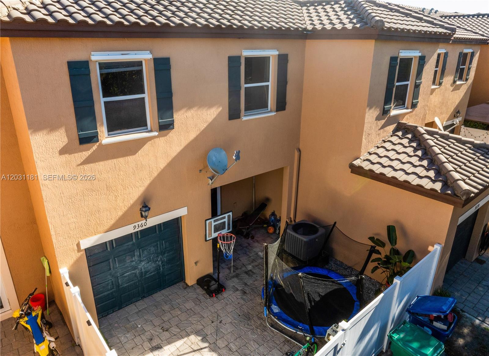 An aerial view shows a house exterior with a garage, patio, trampoline, and basketball hoop — 9360 SW 171st Ct, Miami FL 33196, MIAMI, FL