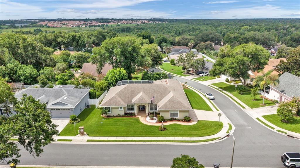 An aerial view shows a single-story house with a tan roof and a corner lot — 5539 BLOOMFIELD BOULEVARD, LAKELAND, FL