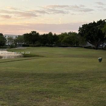 A view of a golf course green with a water hazard and surrounding trees — 9495 Evergreen Pl # 102, Davie FL 33324, DAVIE, FL