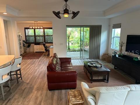 A living room features a red leather sofa, wood-look flooring, and sliding glass patio doors — 5262 ASHER COURT, SARASOTA, FL