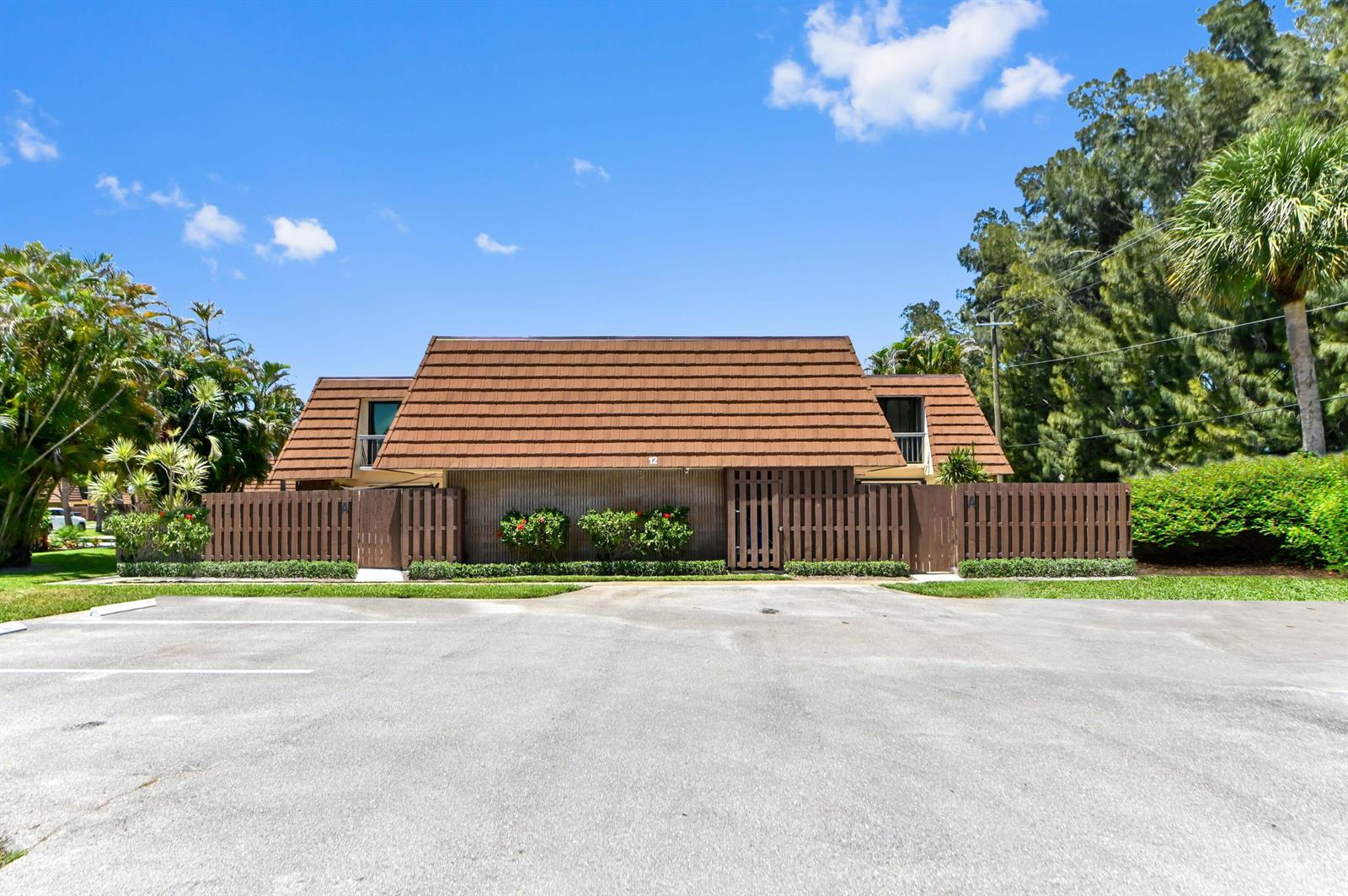 A two-story building with a brown tiled roof and a wooden privacy fence — 825 Center Street # 12a, Jupiter FL 33458, JUPITER, FL