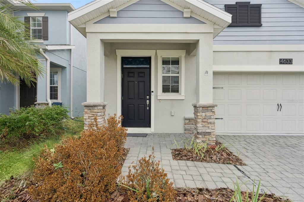 A single-story house with light blue siding, a stone-accented entryway, and a paved driveway — 4633 FAIRY TALE CIRCLE, KISSIMMEE, FL
