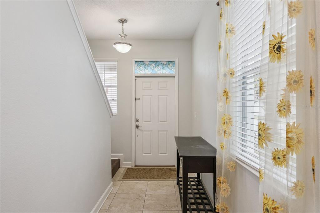 A two-story house exterior features a stone-accented entryway, a black front door, and a driveway — 4633 FAIRY TALE CIRCLE, KISSIMMEE, FL