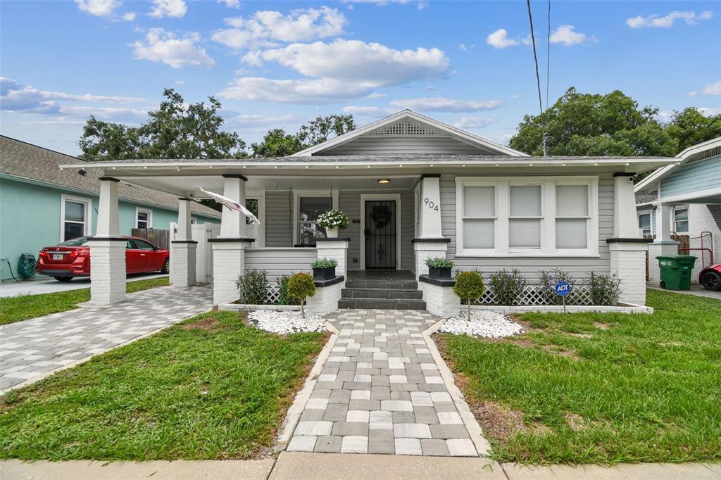 A gray bungalow with a front porch, white columns, and a paved walkway — 904 E HAMILTON AVENUE, TAMPA, FL