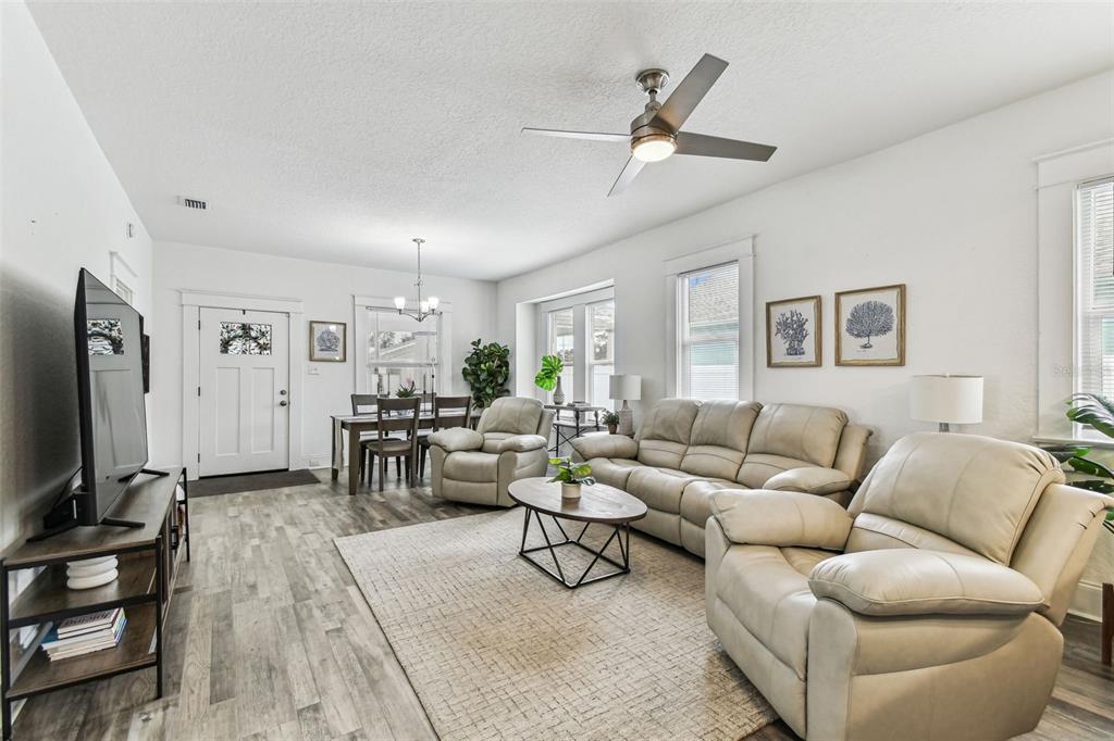 A living room features light wood-look flooring, a ceiling fan, and beige leather furniture — 904 E HAMILTON AVENUE, TAMPA, FL