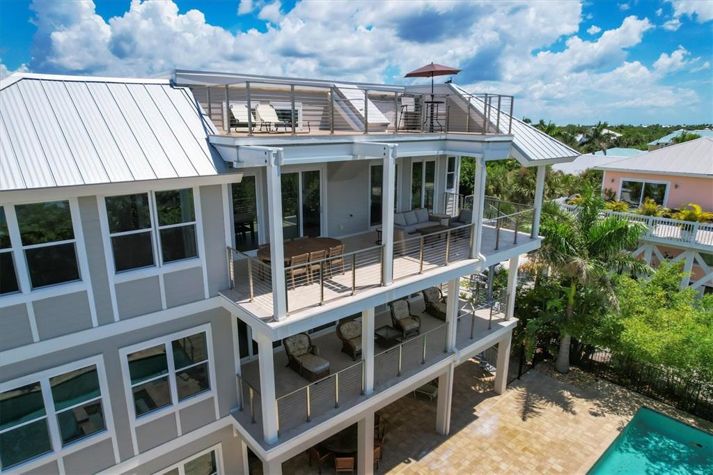 An aerial view of a multi-story house with tiered balconies, a metal roof, and pool — 300 GASPARILLA STREET, BOCA GRANDE, FL