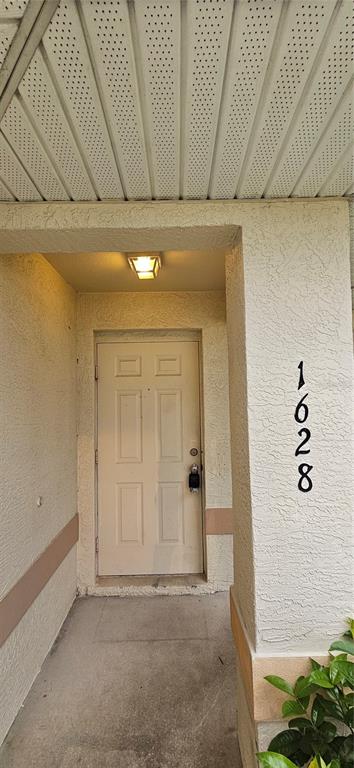 A covered entryway features a white door with a lockbox and the number 1628 displayed — 1628 SW SANTA BARBARA PLACE, CAPE CORAL, FL