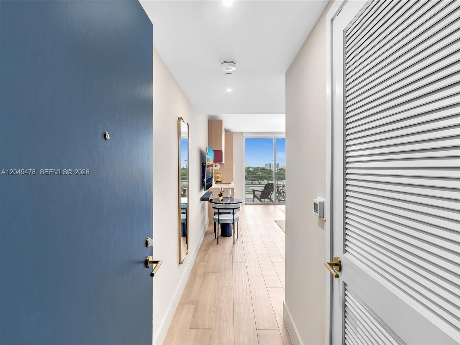 A view from an entryway looking down a hallway toward a balcony and kitchen — 90 NE 32nd st # 724, Miami FL 33137, MIAMI, FL