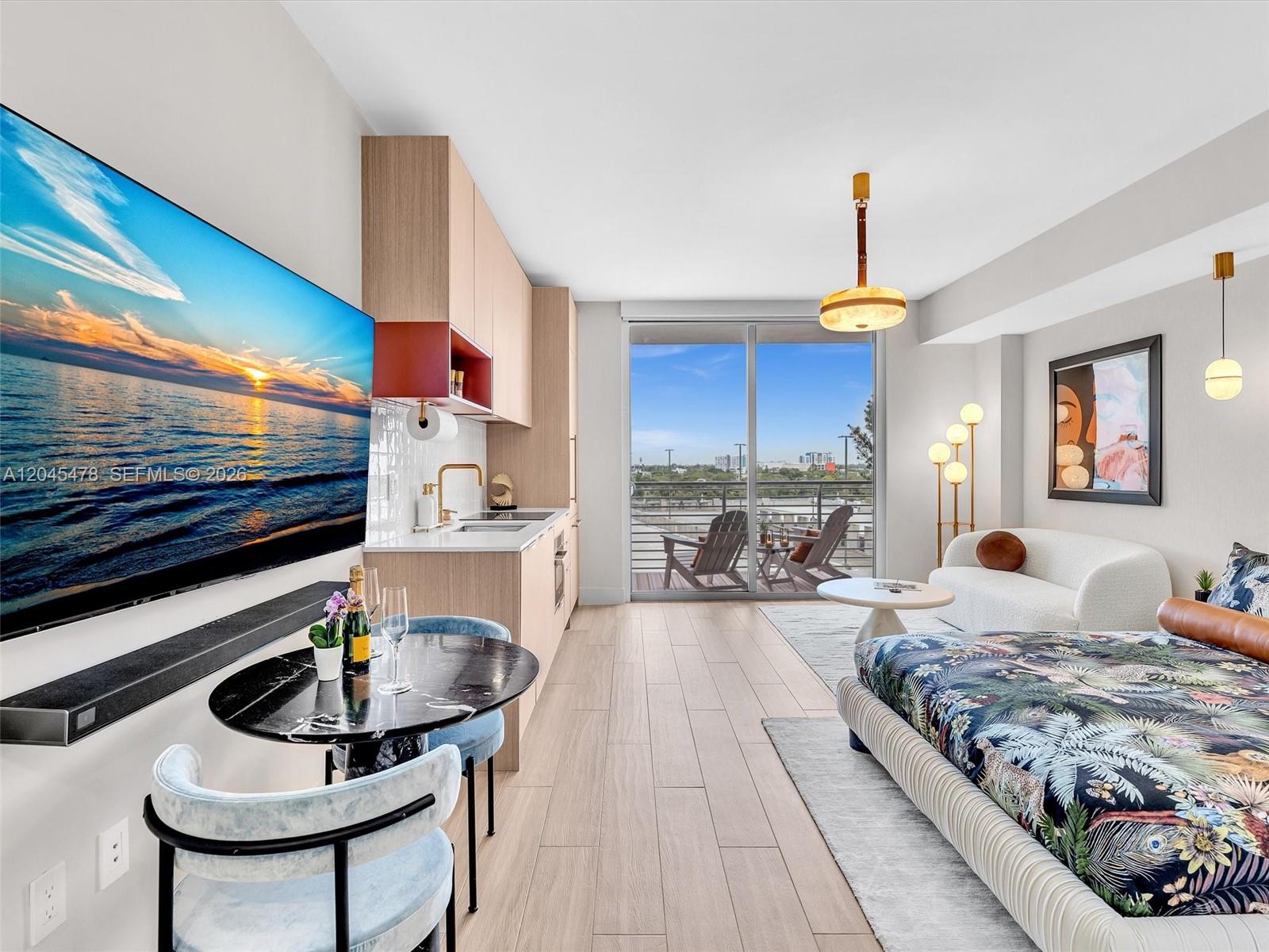 A studio apartment features a kitchenette, a dining area, and a bed near a balcony — 90 NE 32nd st # 724, Miami FL 33137, MIAMI, FL