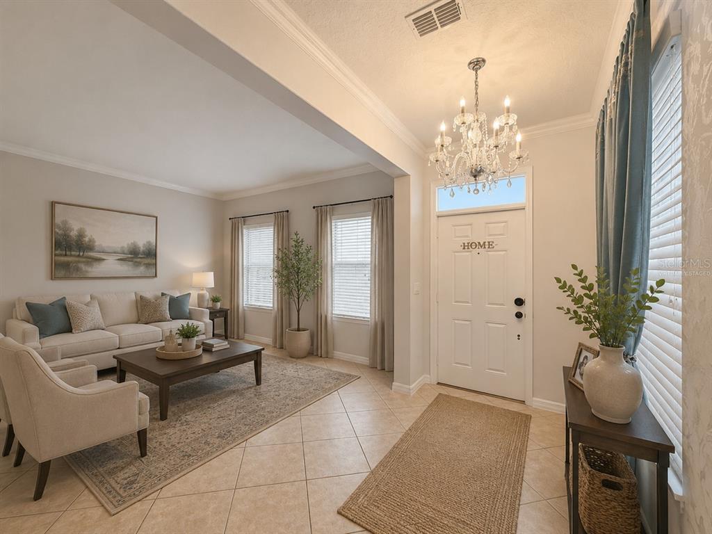 A living room with tile floors, a chandelier, and a white front door — 1185 SEBURN ROAD, APOPKA, FL