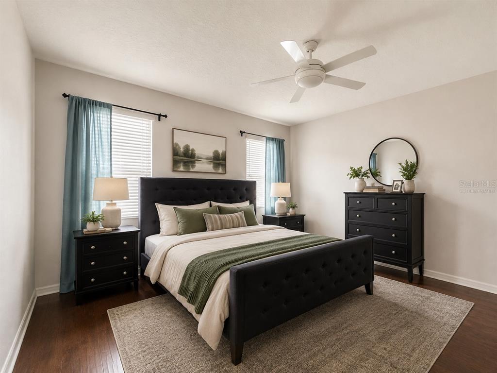 A bedroom features a dark tufted bed, matching nightstands, a dresser, and blue curtains — 1185 SEBURN ROAD, APOPKA, FL