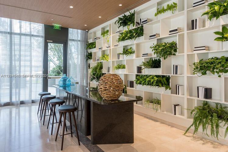 A modern room features a dark stone bar, barstools, and a large white shelving unit — 55 SW 9th St # 1001, Miami FL 33130, MIAMI, FL