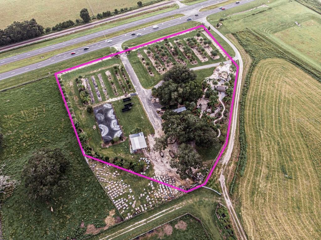 An aerial view shows a property with a nursery, large trees, and several outbuildings — 13494 N US HWY 301, OXFORD, FL