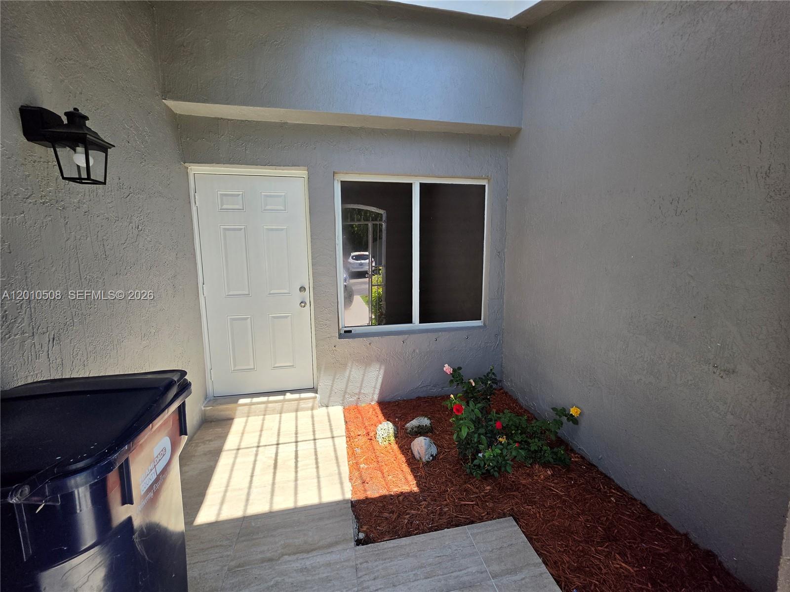 A white door and a window are set into a gray stucco exterior wall — 14775 SW 83rd Ln # 14775, Miami FL 33193, MIAMI, FL