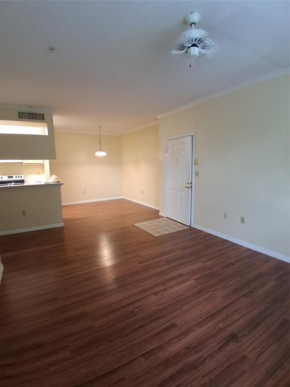 An open-concept living and dining area features wood-look flooring, a ceiling fan, and a kitchen — 5620 PINNACLE HEIGHTS CIRCLE UNIT 303, TAMPA, FL