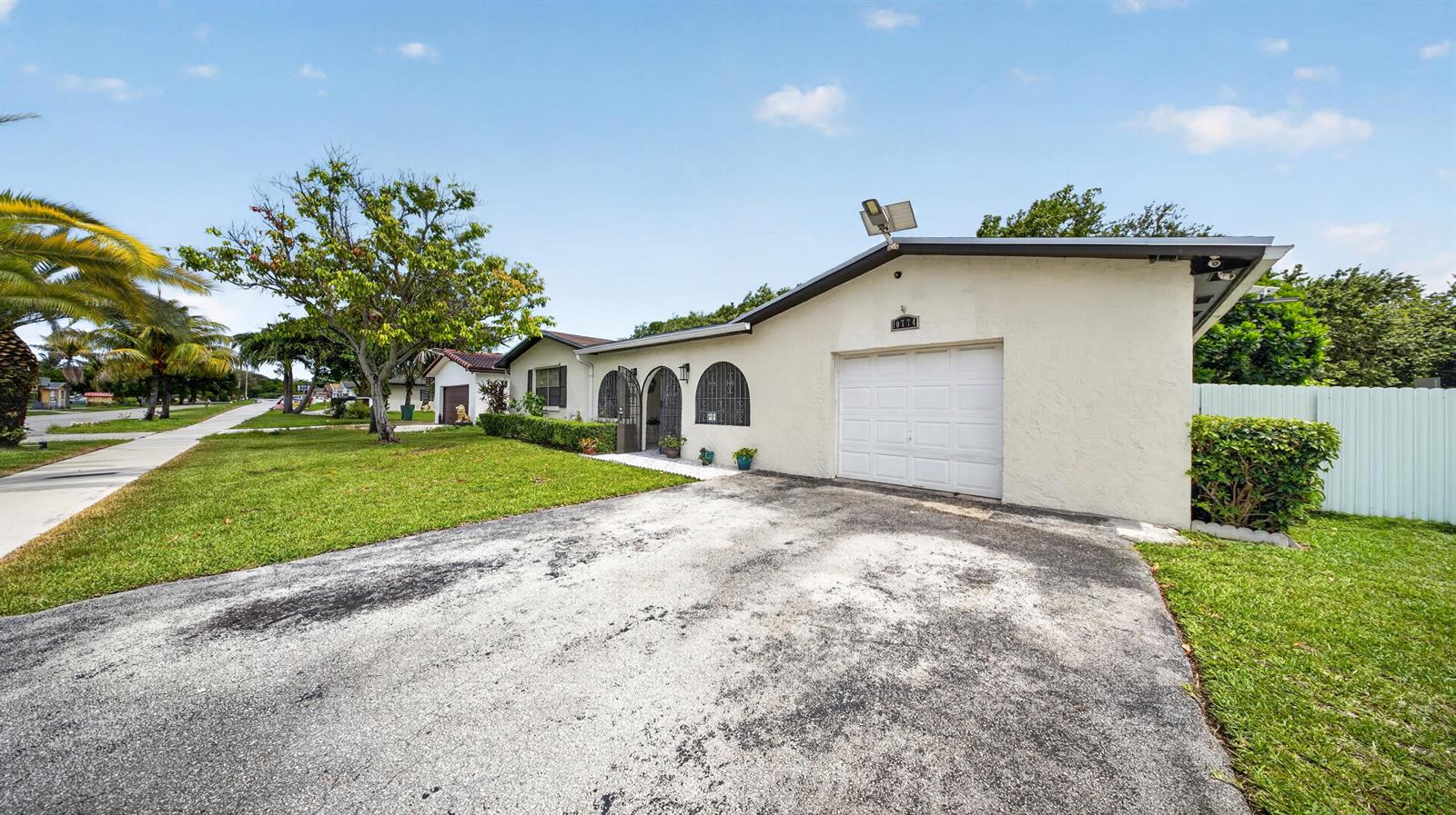 A single-story house with a white stucco exterior, arched windows, and a paved driveway — 10774 SW 175th Terrace, Miami FL 33157, MIAMI, FL