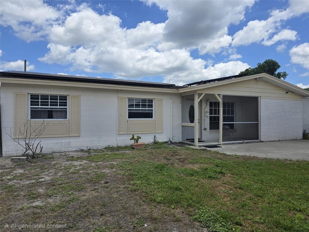 A single-story house with a white block exterior, a screened porch, and a grassy yard — 10325 LOUBET STREET, ORLANDO, FL