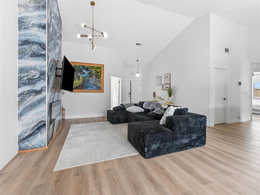 A living room features a blue marble fireplace, a black sectional sofa, and vaulted ceilings — 530 RAPID FALLS DRIVE, BRANDON, FL