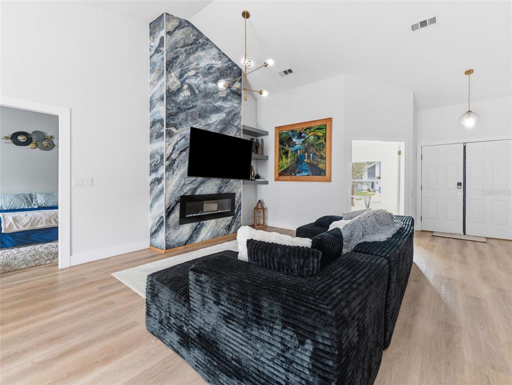 A living room features a blue marble fireplace, a black sectional sofa, and light flooring — 530 RAPID FALLS DRIVE, BRANDON, FL
