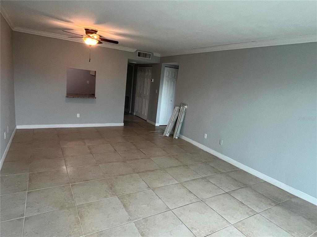 An empty room features light gray walls, large beige floor tiles, and a ceiling fan — 2650 COCONUT BAY LN LANE UNIT 532, SARASOTA, FL