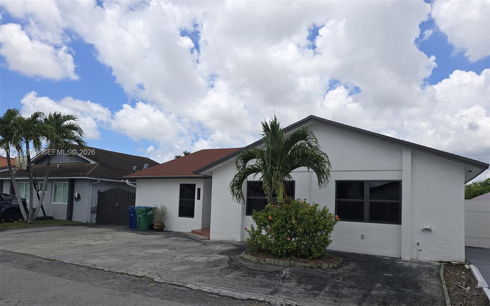 A white single-story house with a paved driveway and a palm tree in the front — 740 SW 99th Ct Cir # 0, Miami FL 33174, MIAMI, FL