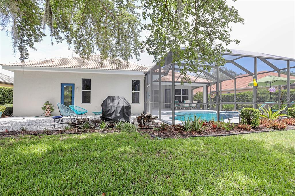 A backyard features a swimming pool enclosed in a screened lanai next to a house — 956 SCHERER WAY, OSPREY, FL