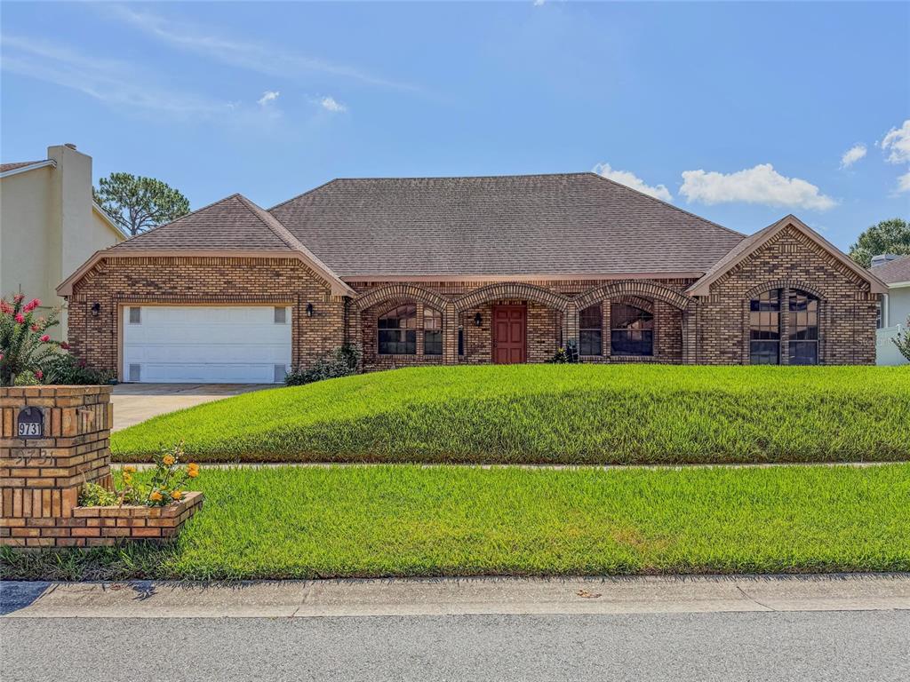 A single-story brick house with a two-car garage and an arched entryway — 9731 SIBLEY CIRCLE, ORLANDO, FL