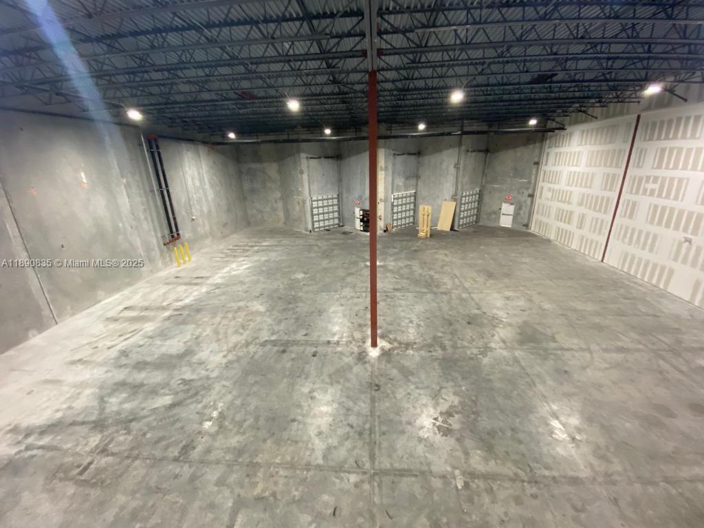An empty industrial warehouse space features concrete walls, a high ceiling, and a central pillar — 13202 NW 107th Ave # 5, Hialeah Gardens FL 33018, HIALEAH GARDENS, FL
