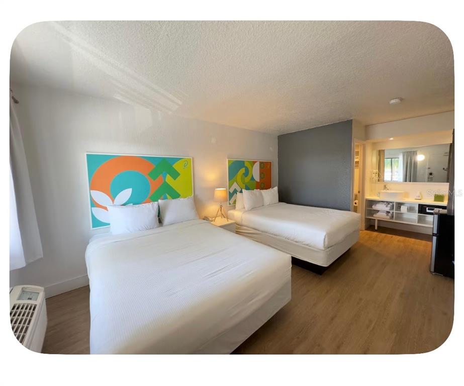 A hotel room with two beds, wood-look flooring, and an open vanity area — 5367 W IRLO BRONSON MEMORIAL HIGHWAY UNIT 1-206, KISSIMMEE, FL