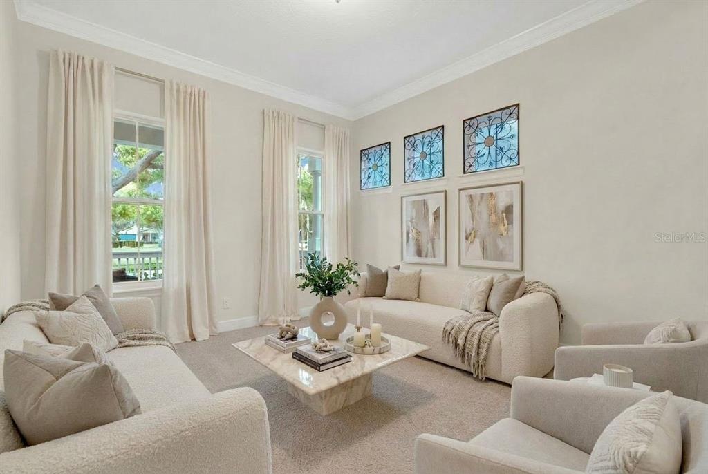 A bright living room features two cream sofas, a marble coffee table, and wall art — 11734 ALDENDALE STREET, ORLANDO, FL