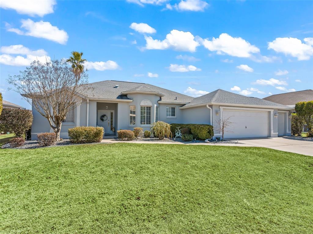A single-story house with a gray exterior, a two-car garage, and a front lawn — 2449 NW 59TH TERRACE, OCALA, FL