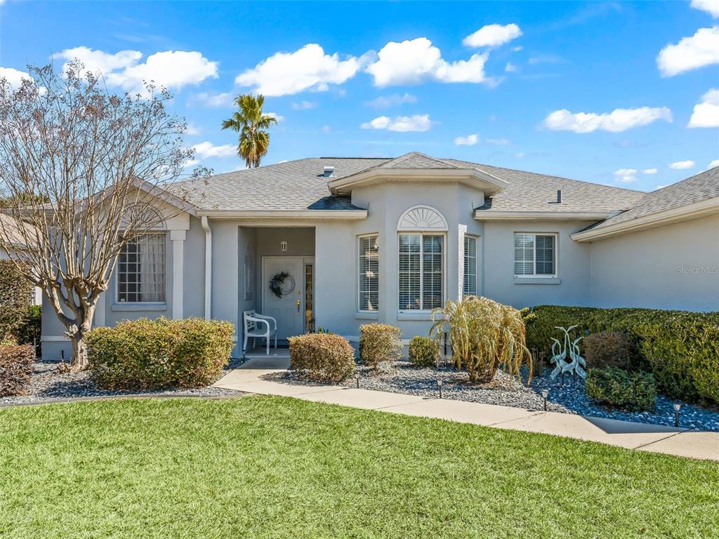 A single-story house with a gray exterior, a front porch, and a landscaped yard — 2449 NW 59TH TERRACE, OCALA, FL
