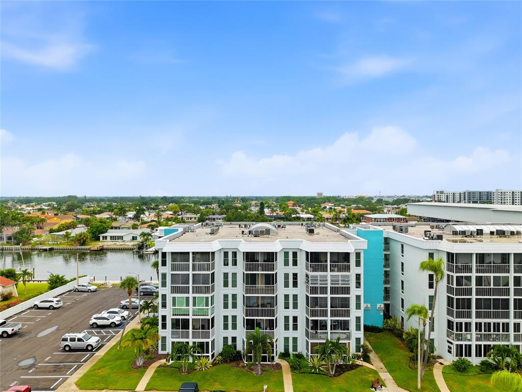 An aerial view shows a multi-story apartment building next to a canal and parking lot — 4900 38TH WAY S UNIT 404, ST PETERSBURG, FL