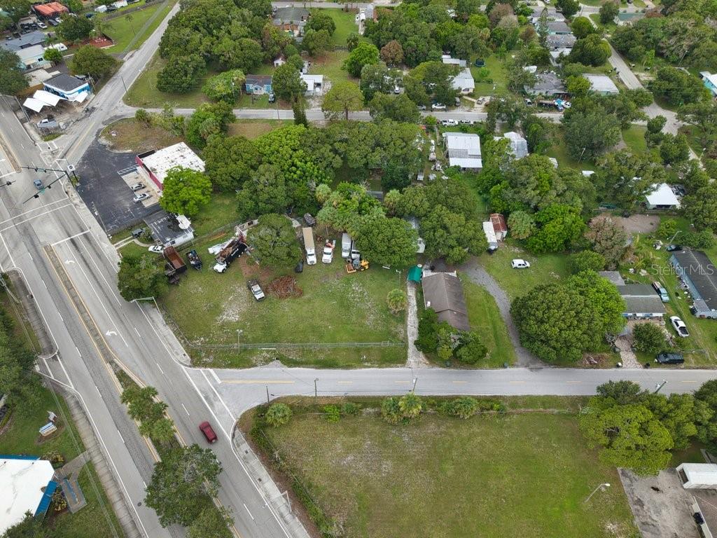An aerial view shows a large grassy lot with several vehicles and a small house — 2108 OKEECHOBEE ROAD, FORT PIERCE, FL