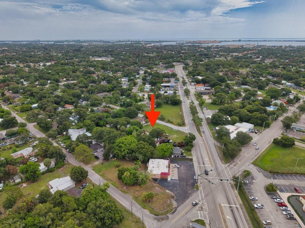 An aerial view shows a vacant lot marked by a red arrow near a road — 2108 OKEECHOBEE ROAD, FORT PIERCE, FL