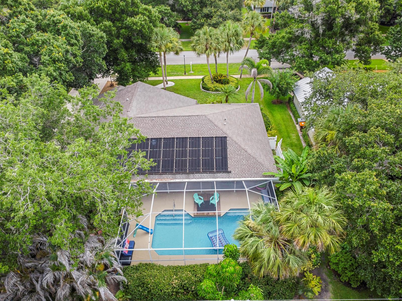 An aerial view of a house with a solar-heated pool inside a screened-in lanai — 129 38th Court, Vero Beach FL 32968, VERO BEACH, FL