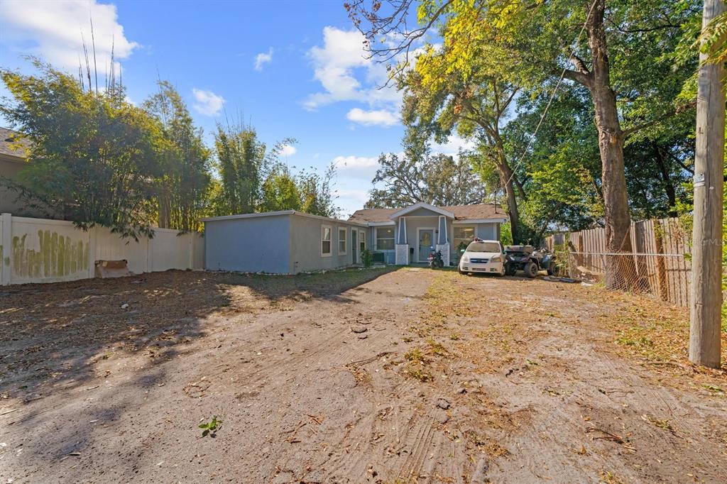 A single-story house with a large, unpaved dirt driveway and a white fence — 4204 N MARGUERITE STREET, TAMPA, FL